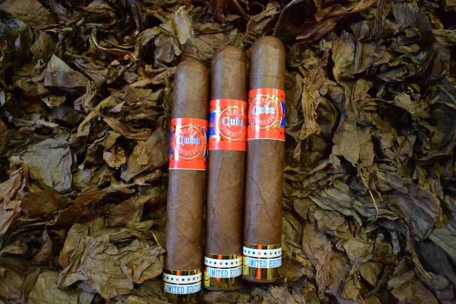 This is a image of a stack of 1 to 5 cigars. They are layed on a of Background feild of tabaco.