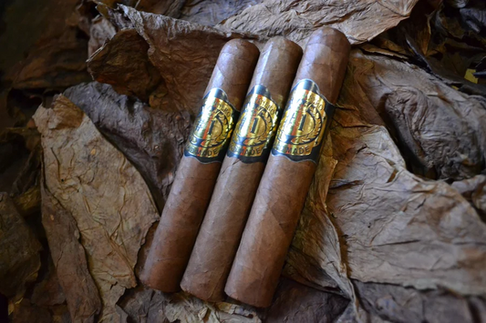 This is a image of a stack of 1 to 5 cigars. They are layed on a of  Background feild of tabaco.