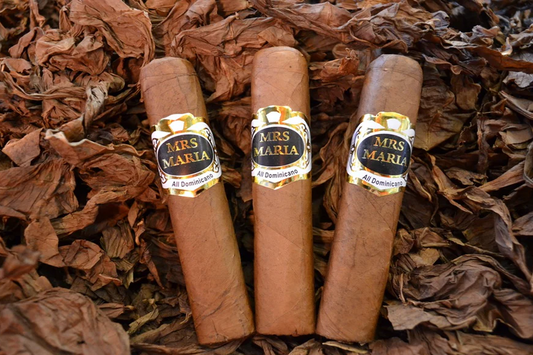 This is a image of a stack of 1 to 5 cigars. They are layed on a of  Background feild of tabaco.